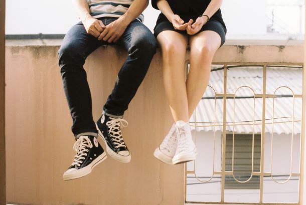 Frau und Mann sitzen auf einer Balustrade