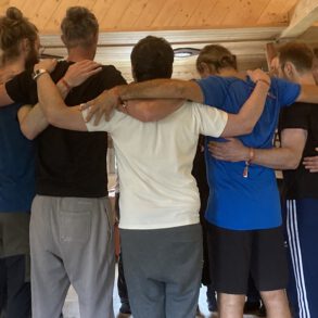 Männer im Kreis, Arm in Arm