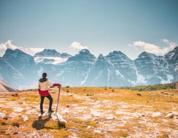 mann der oben auf berg steht und auf eine Bergkette blickt