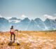 mann der oben auf berg steht und auf eine Bergkette blickt
